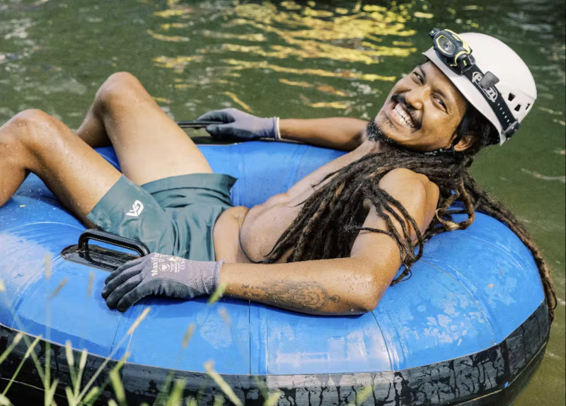 A guest relaxing in a blue tube during the Kauai adventure